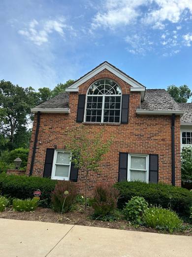 Brick house with a large arched gable window and black shutters
