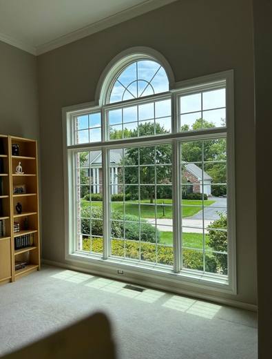 Tall arched picture window with grilles, seen from inside a living room