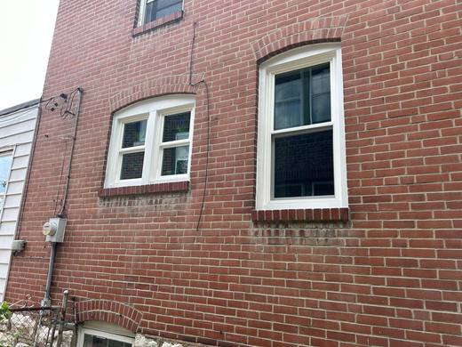 Arched-top replacement windows in a red brick wall