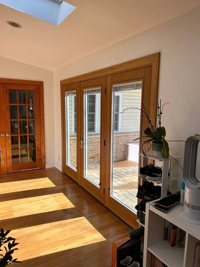 Three-panel wood-finish French patio door in a sunroom